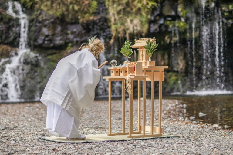 滝の前で祈りを捧げる山村珠紀